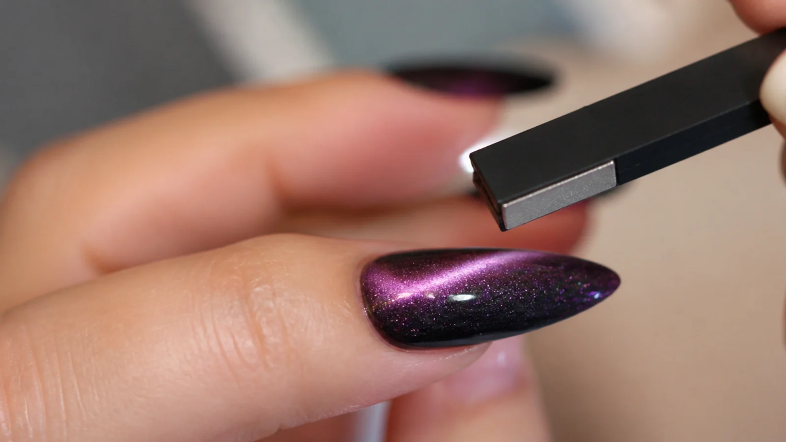 A magnet hovering over a wet magnetic gel tip pulling a bright cat eye stripe