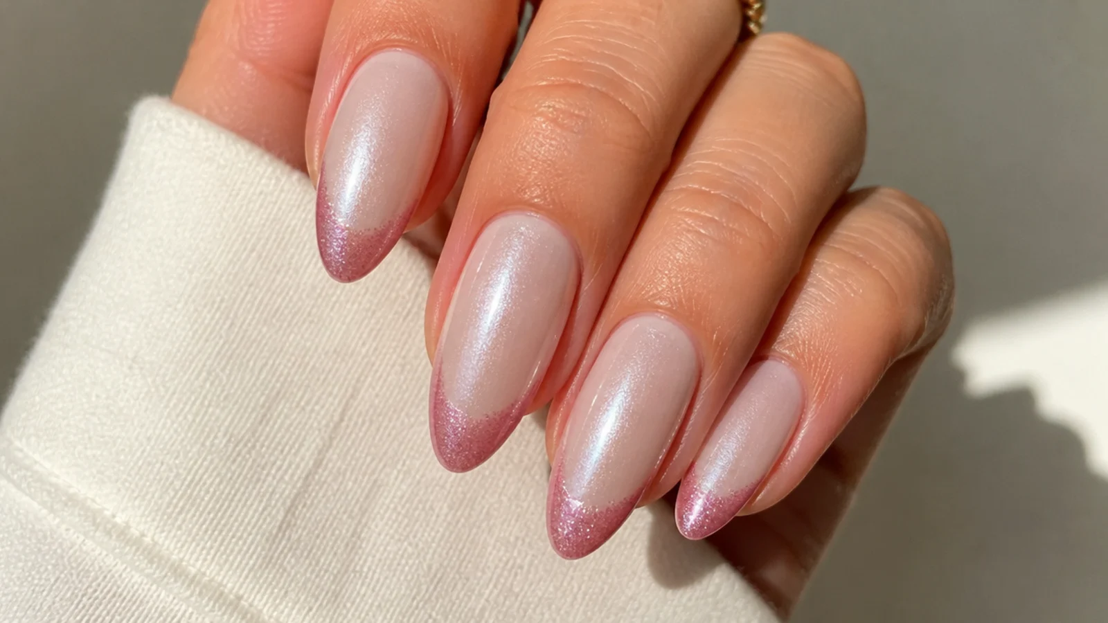 Almond nails with a milky base and a soft pink magnetic cat eye french tip