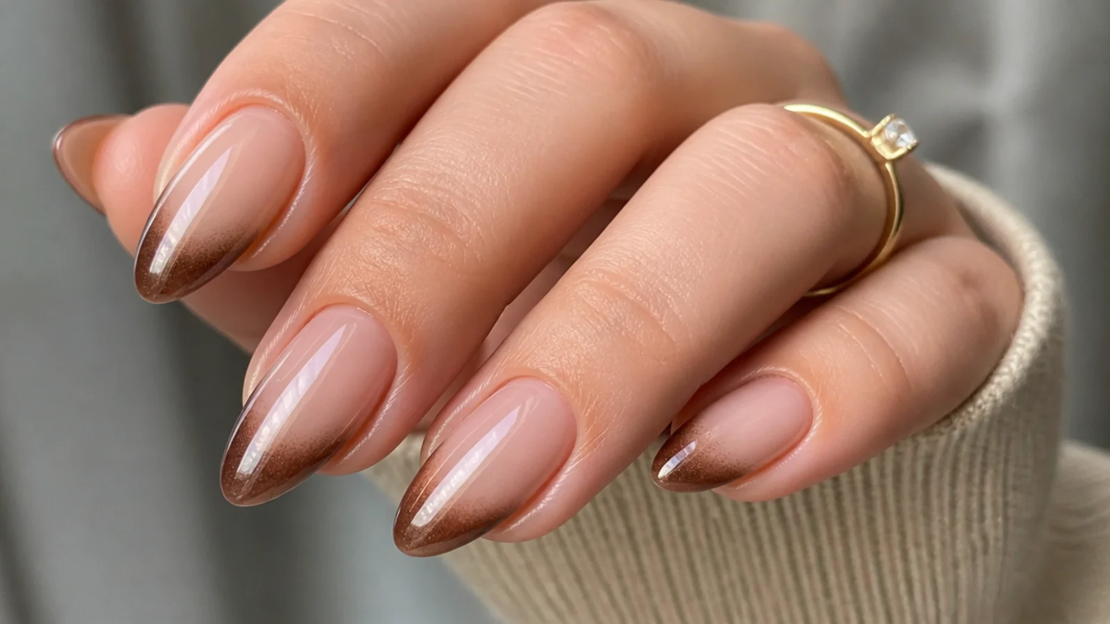 Almond nails with a nude base and a warm mocha brown magnetic cat eye tip