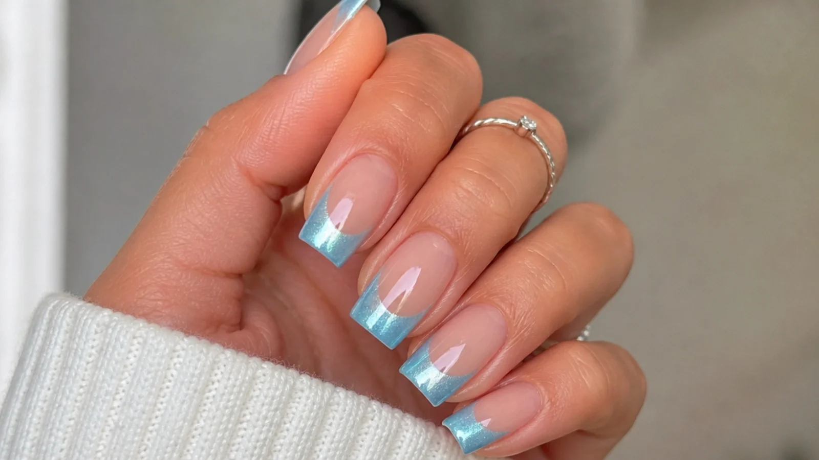 Square nails with a nude base and a soft sky blue magnetic cat eye tip