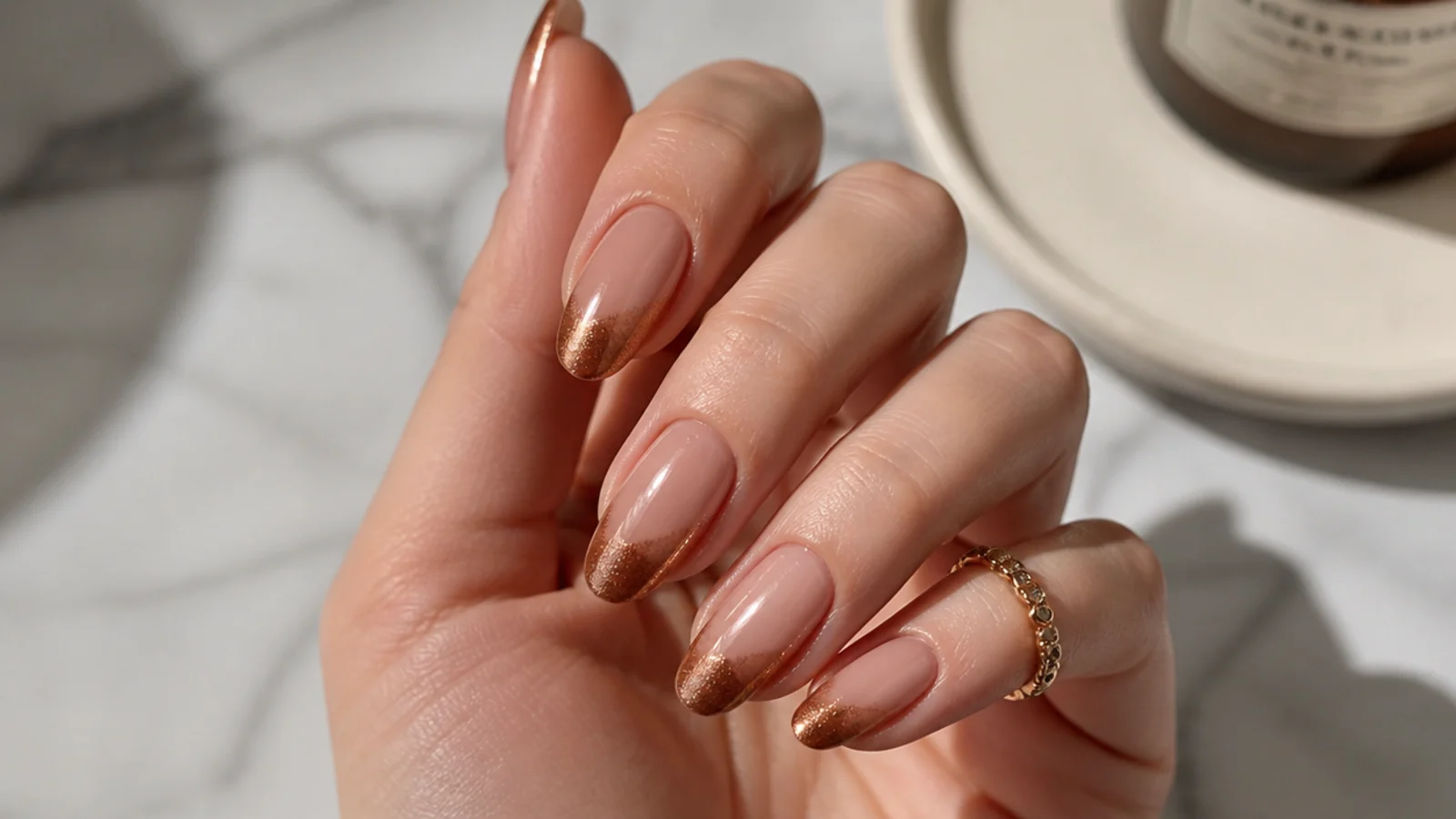 Almond nails with a nude base and a warm caramel bronze magnetic cat eye tip