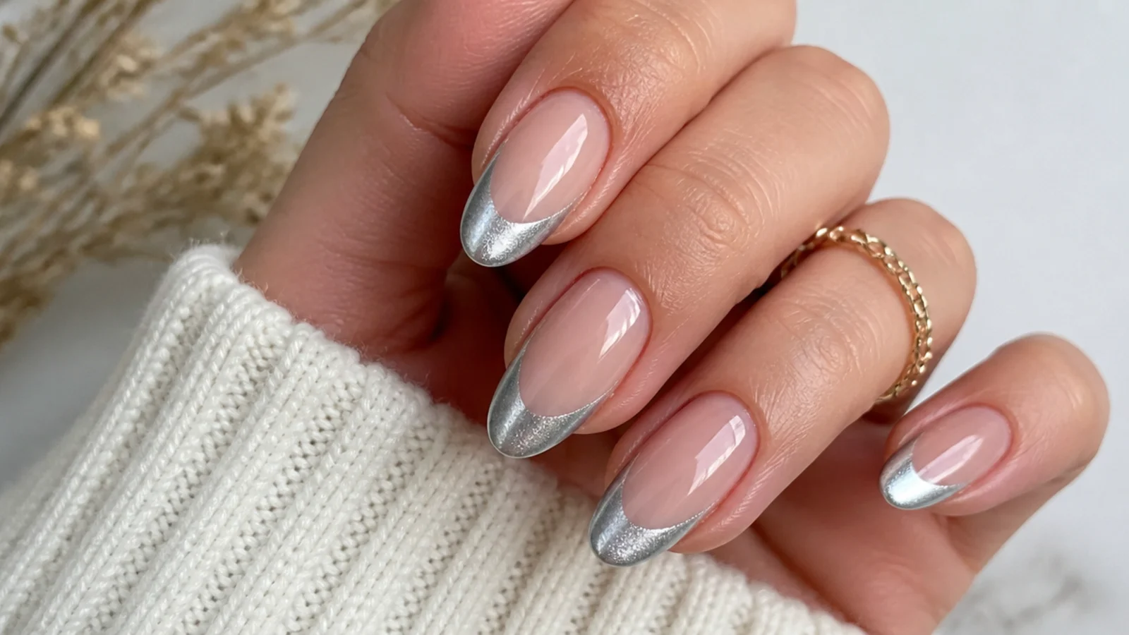Almond nails with a nude base and a bright silver magnetic cat eye stripe along each french tip