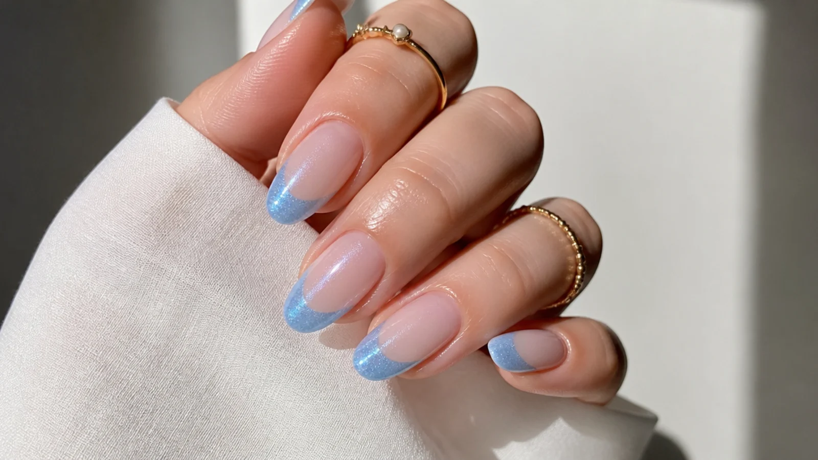 Soft sky blue magnetic cat eye french tip nails on a milky base