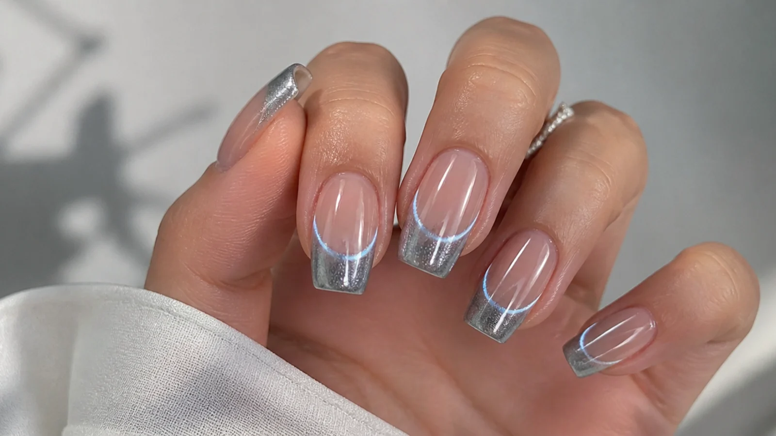 Silver magnetic cat eye french tip with a mirror-like light band on square nails