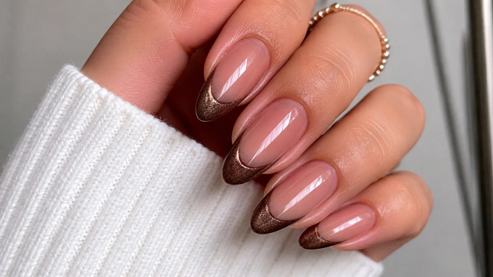 Warm brown magnetic cat eye french tip with a soft light band on almond nails
