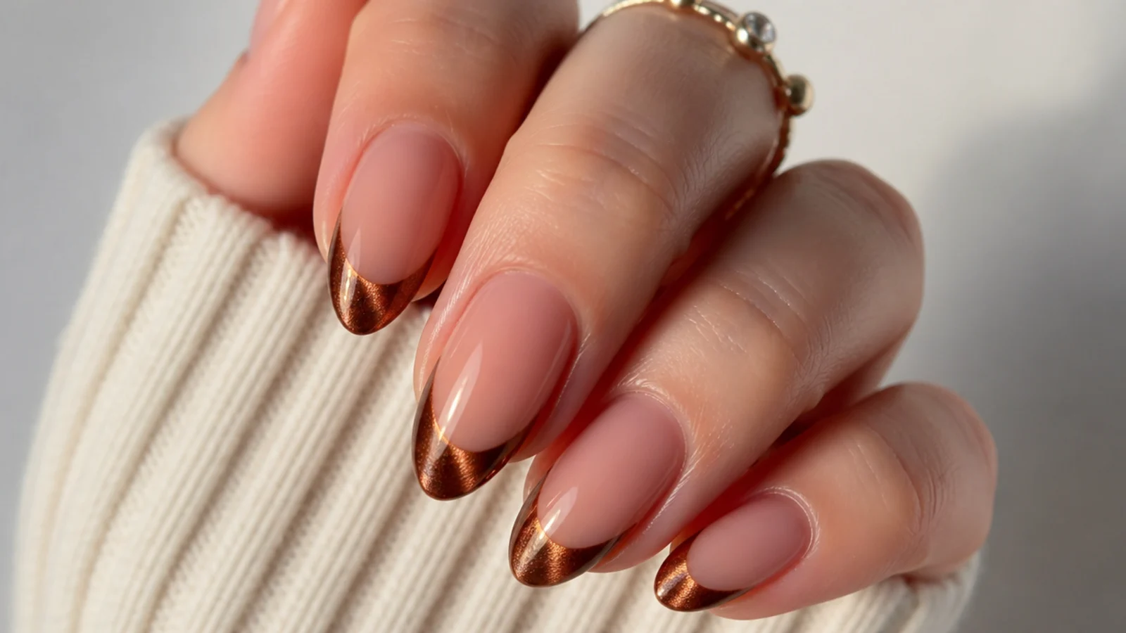 Warm copper chrome cat eye french tip nails with a bronze light stripe