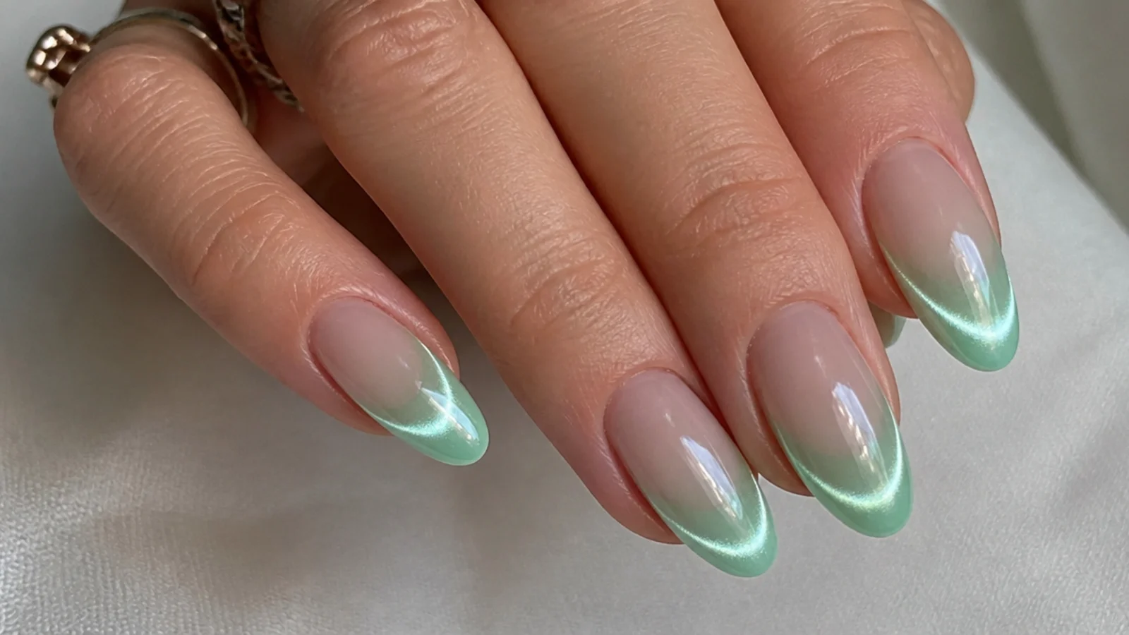 Mint green chrome cat eye french tip nails with a cool light band