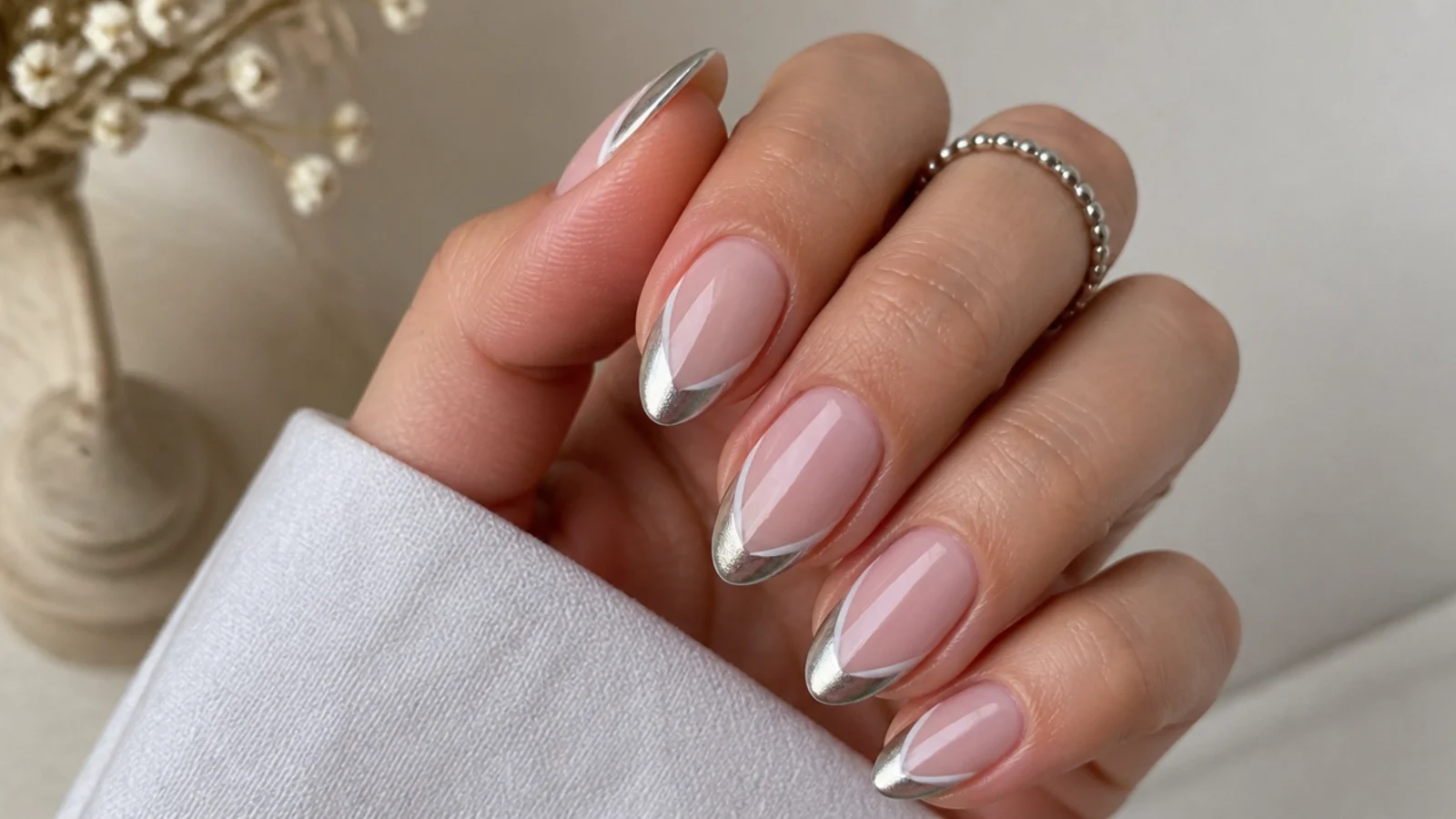 Silver chrome french tip nails with a diagonal side-swept light stripe