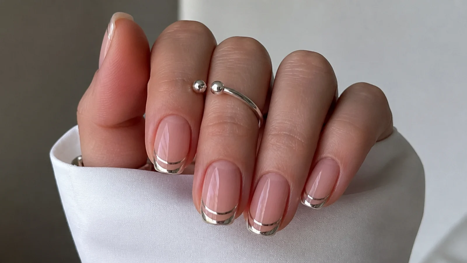 Bare nails with a floating chrome french tip separated by a negative space line