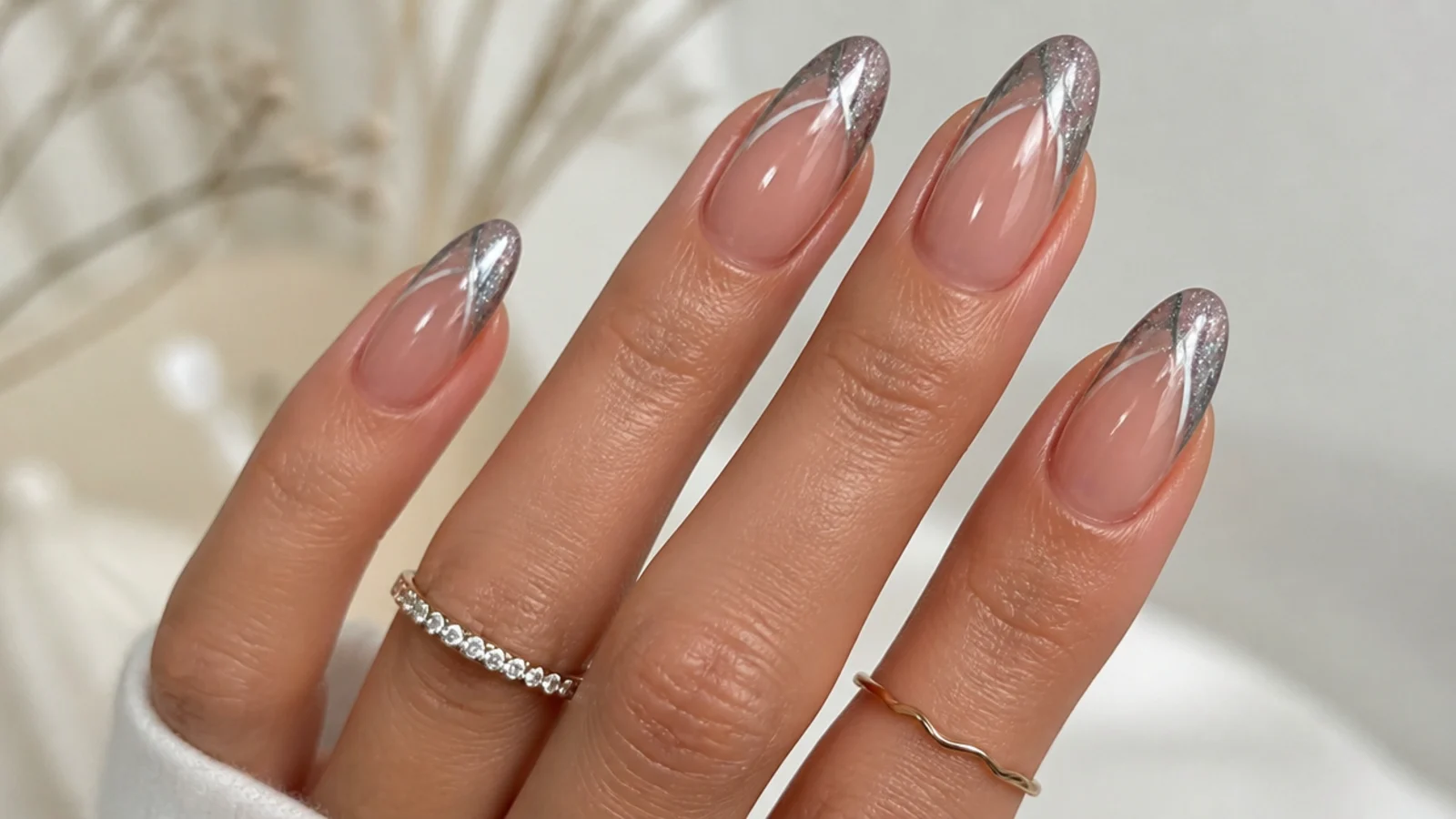 Silver chrome cat eye french tip nails with a bright 3D light stripe on almond shapes