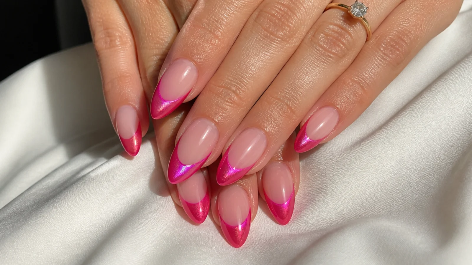 Bold hot pink cat eye french tip nails with a bright magnetic light band