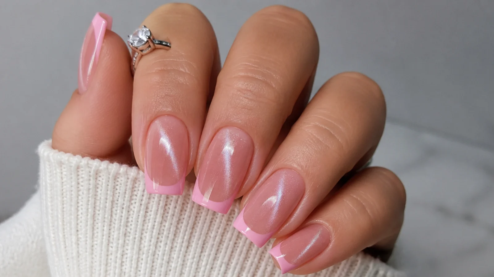 Pink cat eye french tip nails with a cool silver light stripe on a square shape
