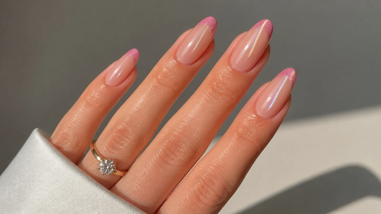Pale pink cat eye french tip nails with a faint light stripe on natural nails