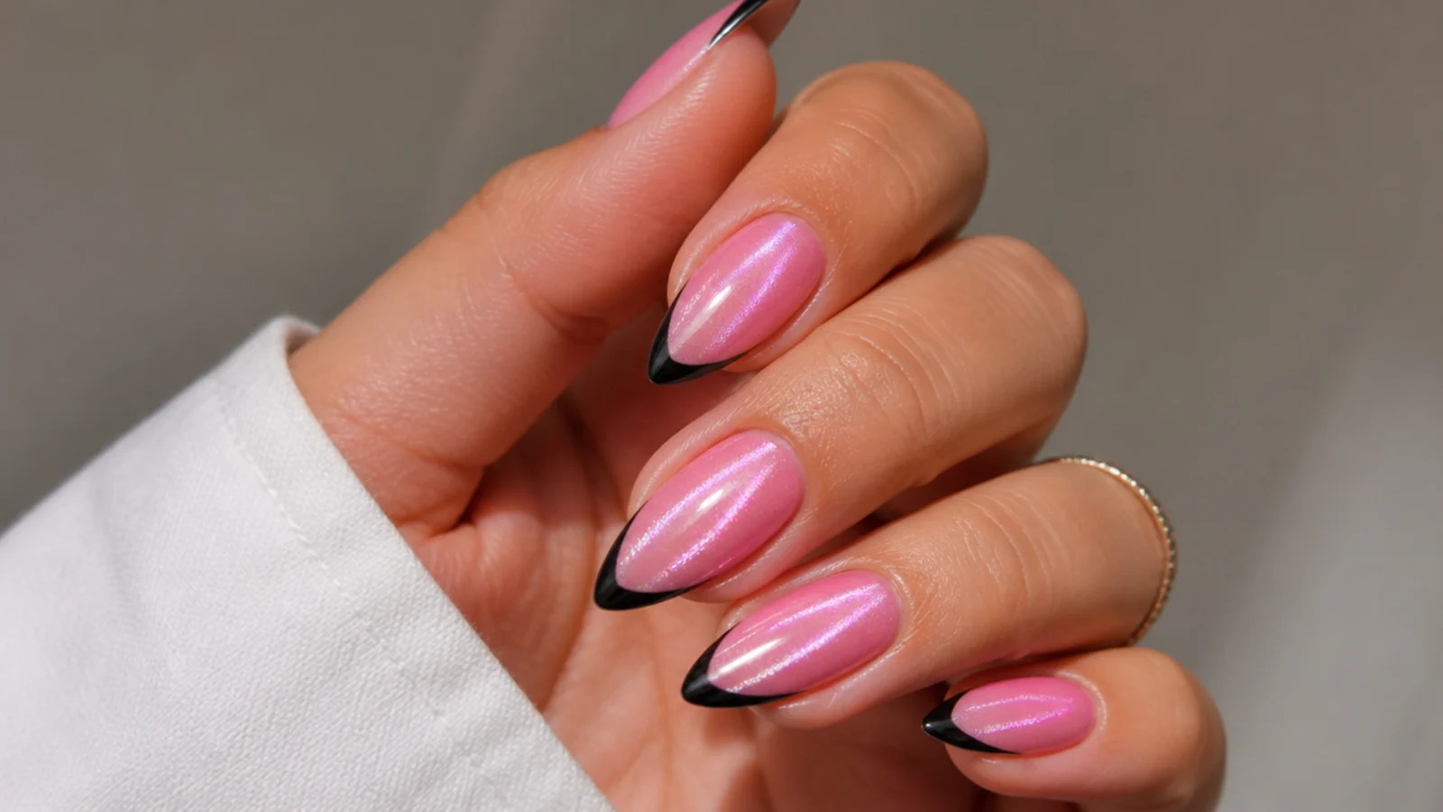 Pink cat eye french tip nails with a black outline for an edgy look