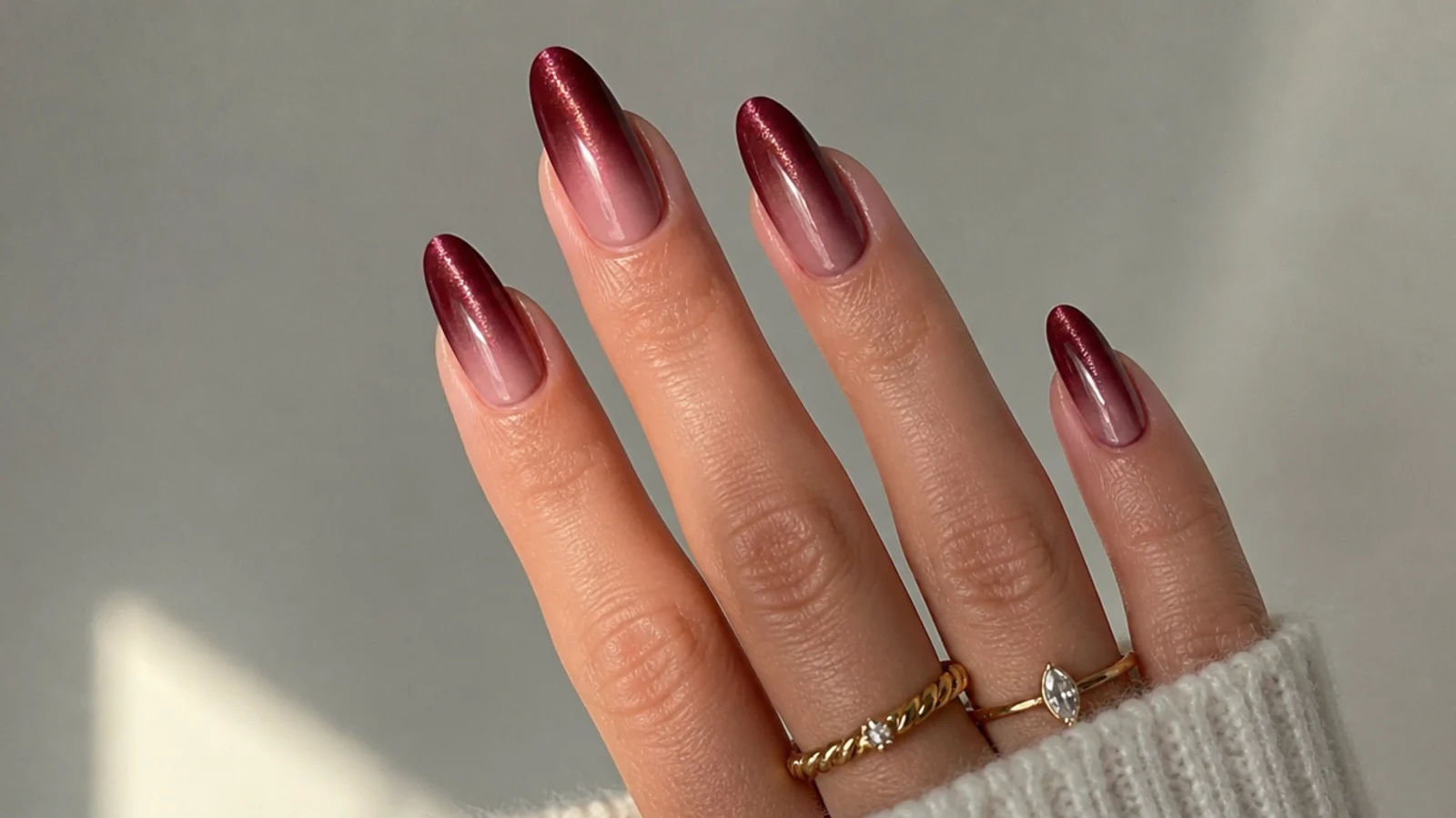 Burgundy wine cat eye french tip nails on almond shape with a soft glowing stripe