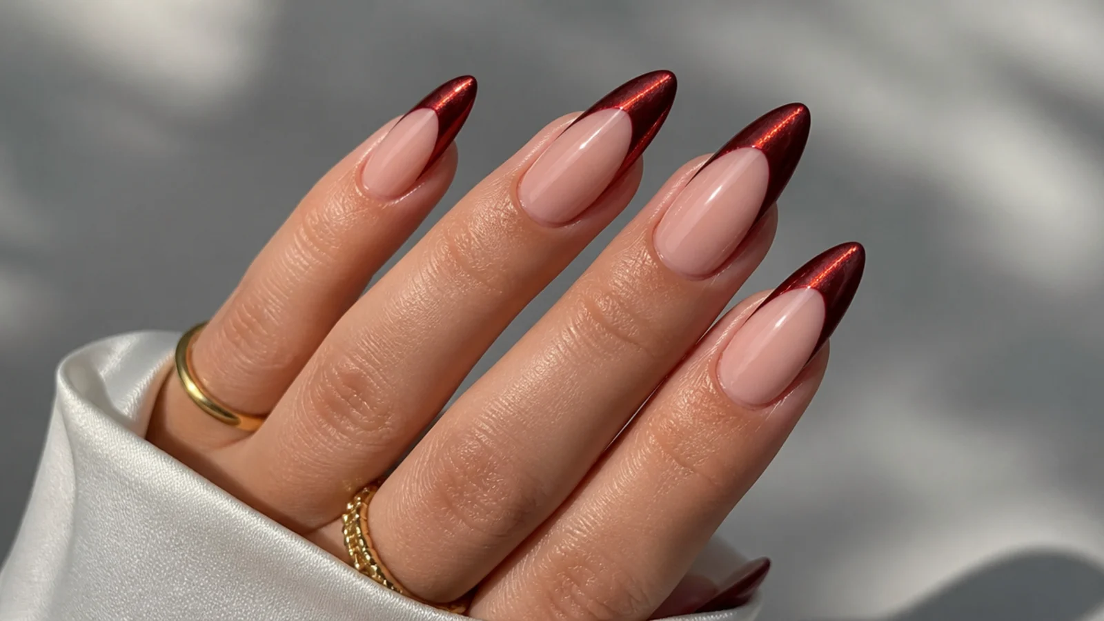 Metallic red chrome cat eye french tip nails on almond shape with a mirror-bright stripe