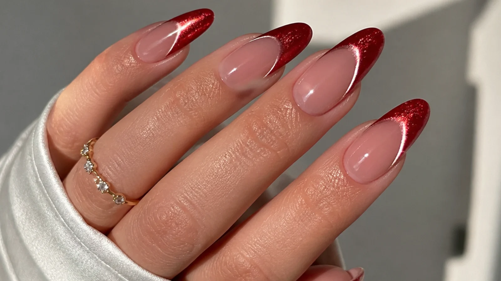 Red glitter cat eye french tip nails on almond shape with a sparkling light stripe