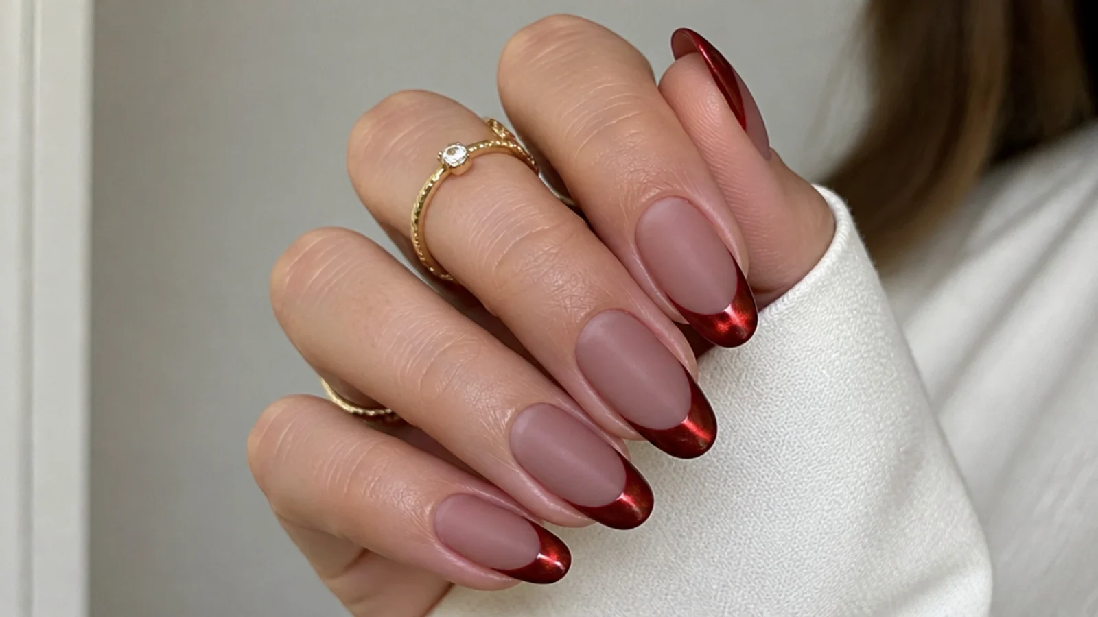 Matte red cat eye french tip nails on almond shape with a single soft glowing stripe
