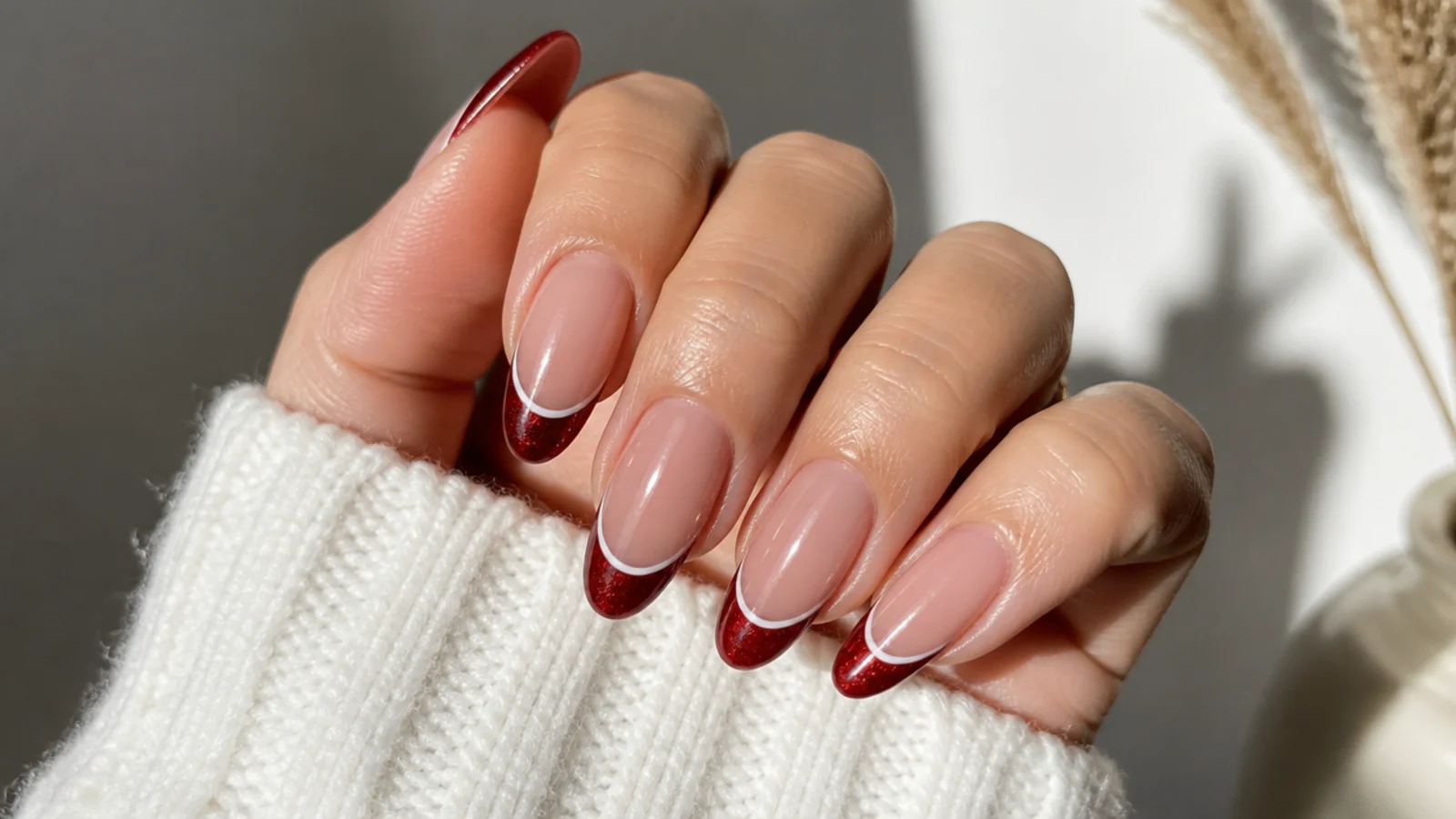 Red cat eye french tip nails with a thin white line underneath on almond shape