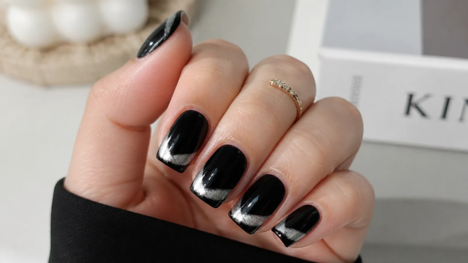 Silver cat eye french tip over a black base on square nails with a bright stripe