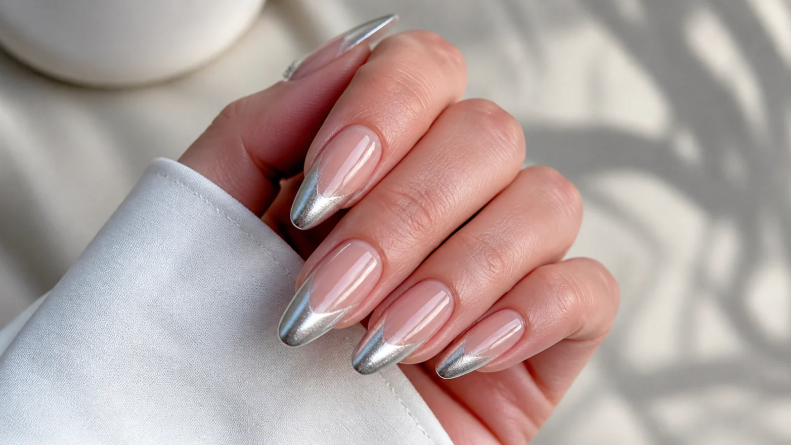 Long almond nails with a silver cat eye french tip and elongated light stripe