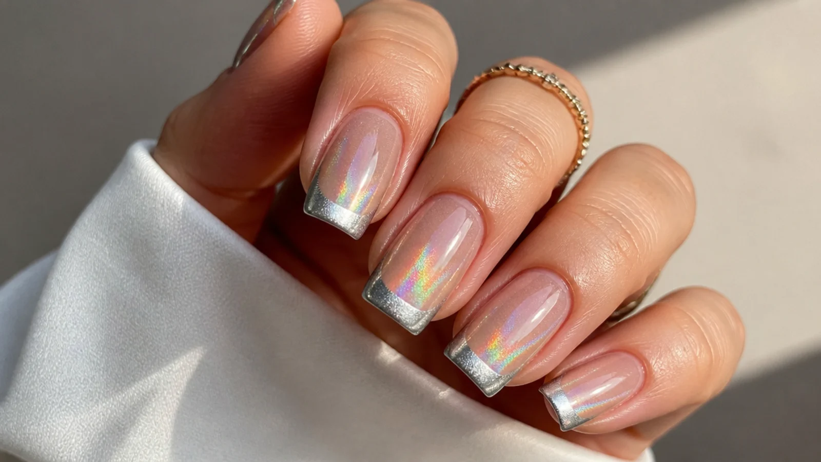 Silver cat eye french tip with a rainbow holographic flash on square nails