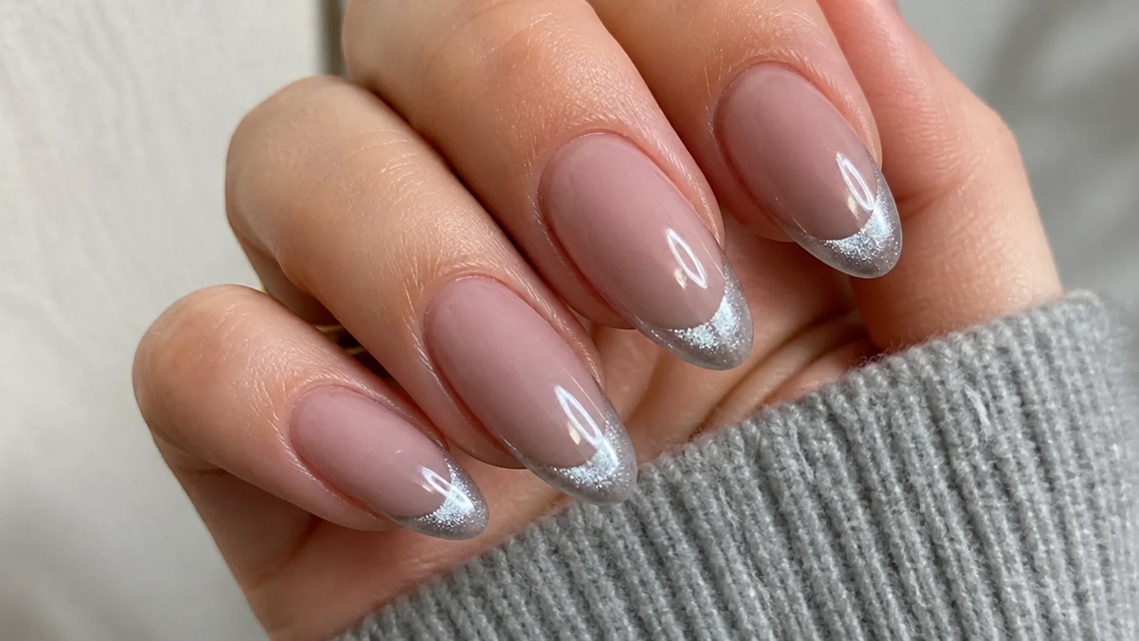Silver cat eye french tip nails with a bright 3D light stripe at the tips on an almond shape