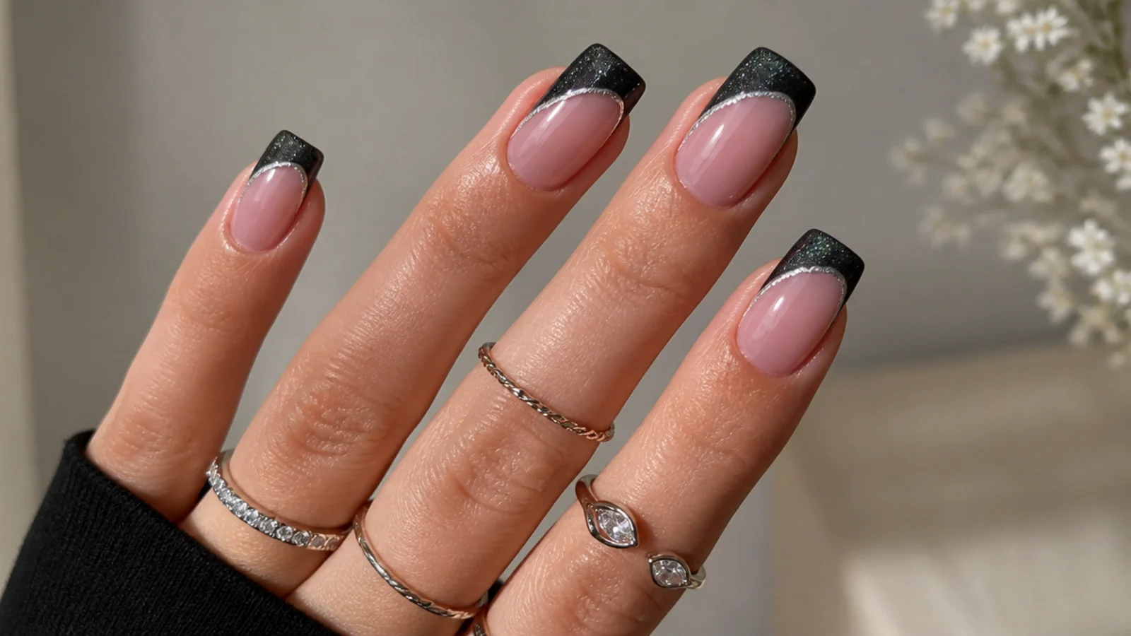 Square nails with a deep black magnetic cat eye french tip and silver stripe