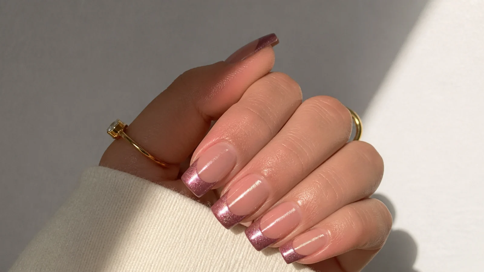 Square nails with a magnetic cat eye french tip catching a bright stripe of light