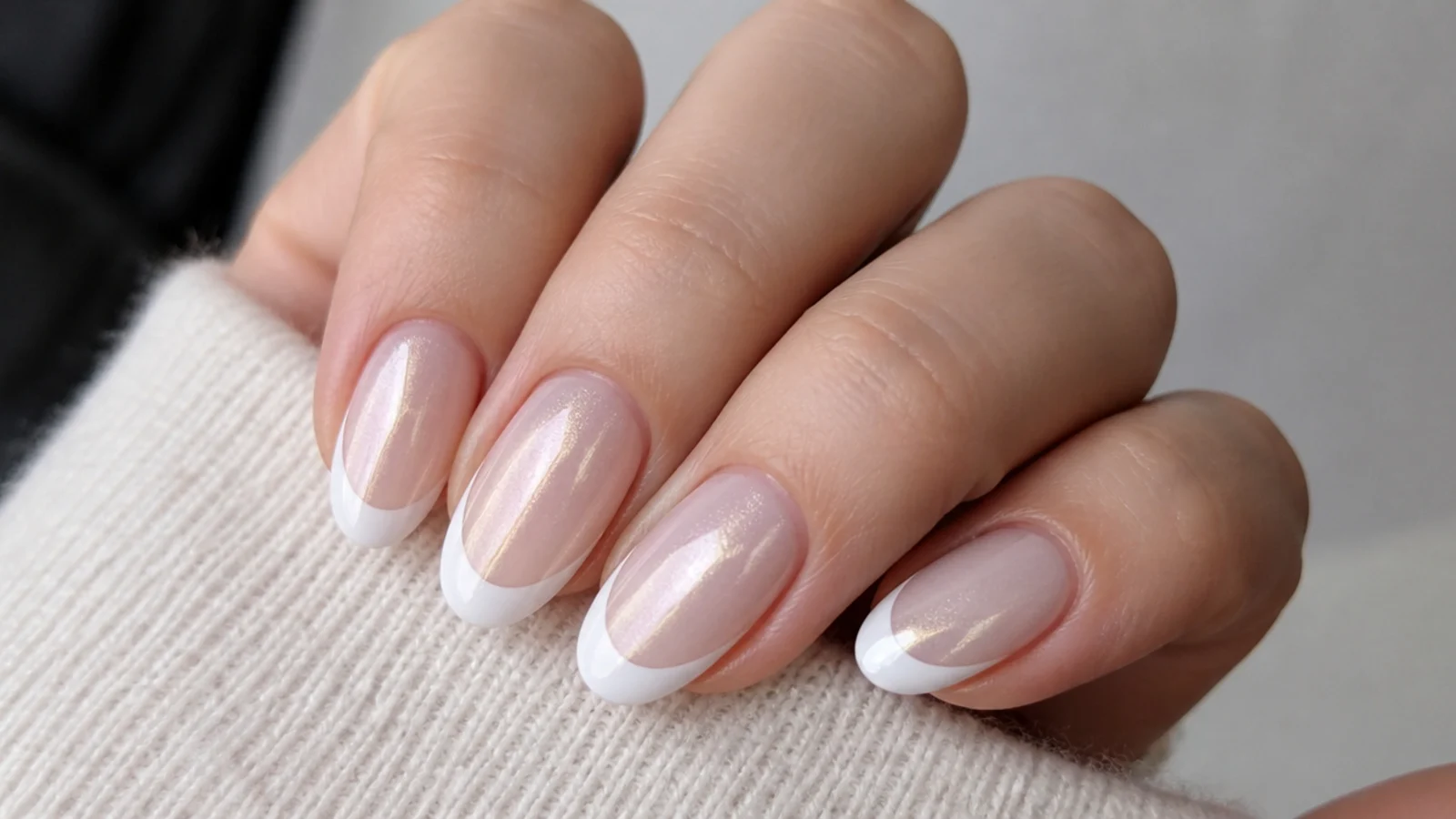 Pearly white cat eye french tip nails with a soft iridescent light band