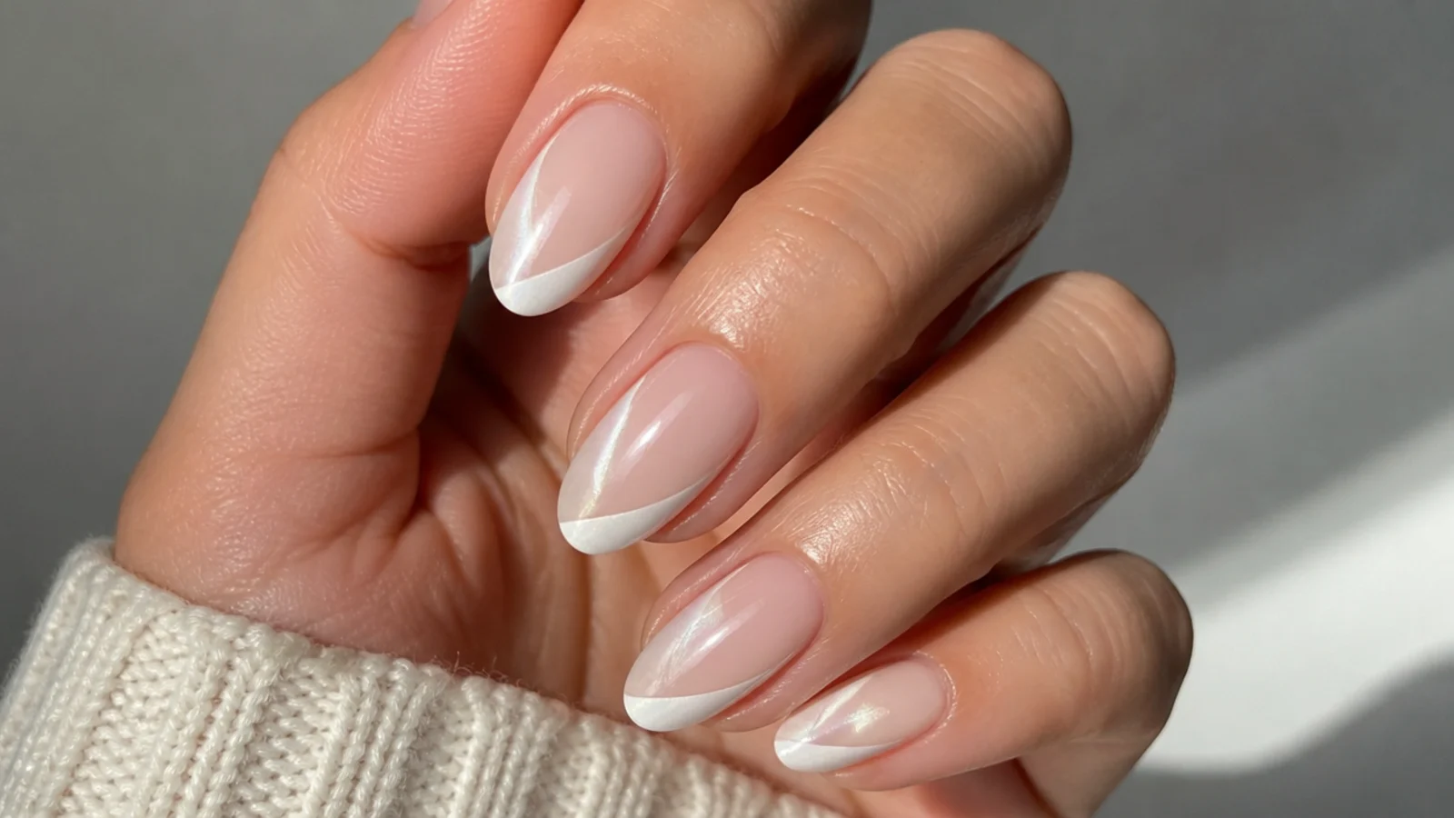 White cat eye french tip nails with a diagonal light stripe across each tip