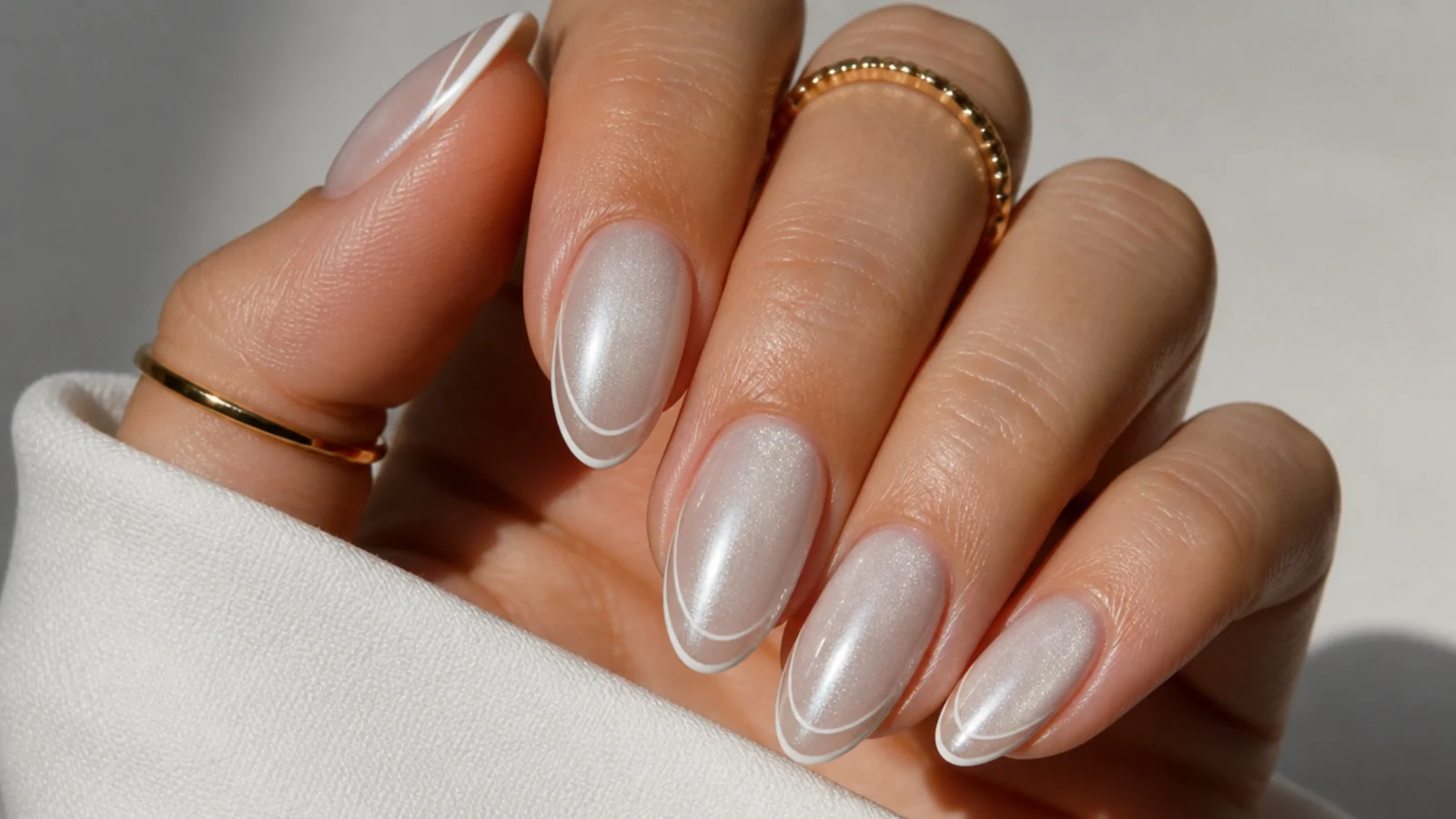 White cat eye french tip nails with a very thin delicate tip and fine light line