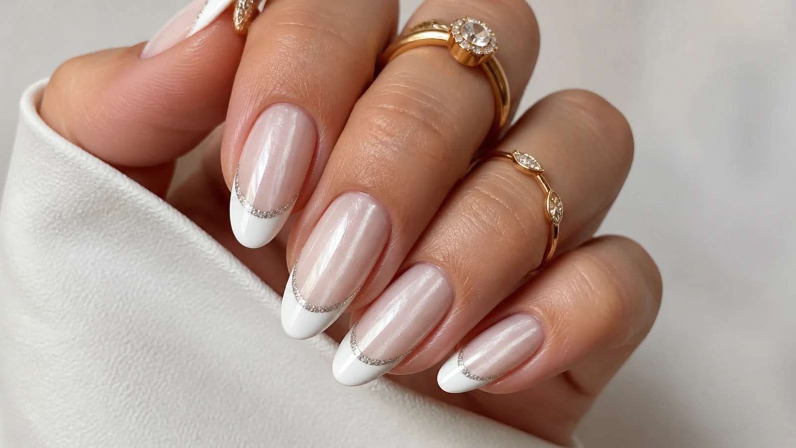 White cat eye french tip nails with fine silver glitter along the smile line