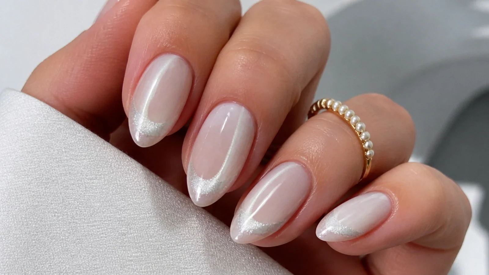 Milky white cat eye french tip nails with a bright magnetic light stripe at the tips on almond nails