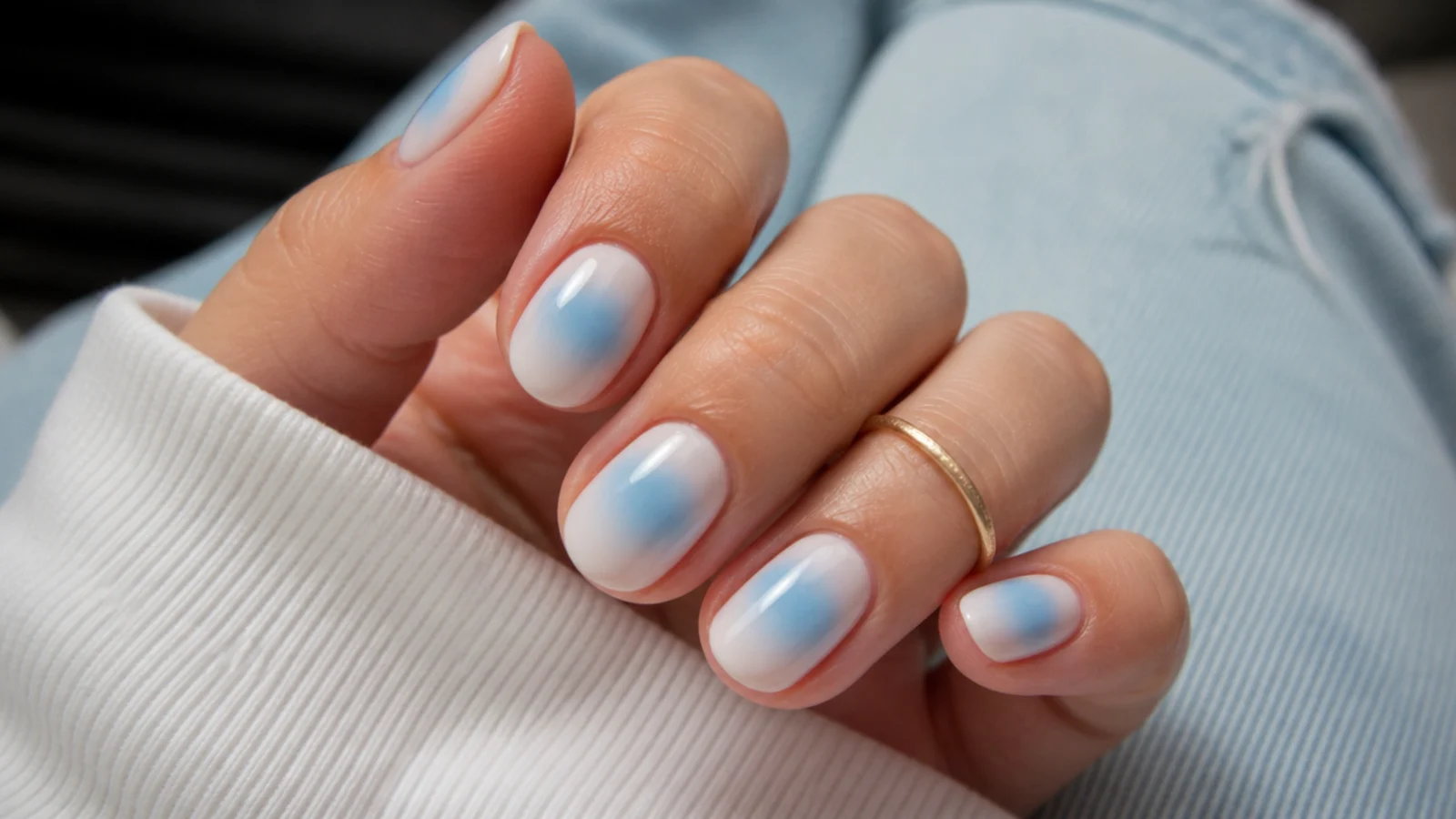 Short almond nails with a baby blue aura halo fading into a milky white base