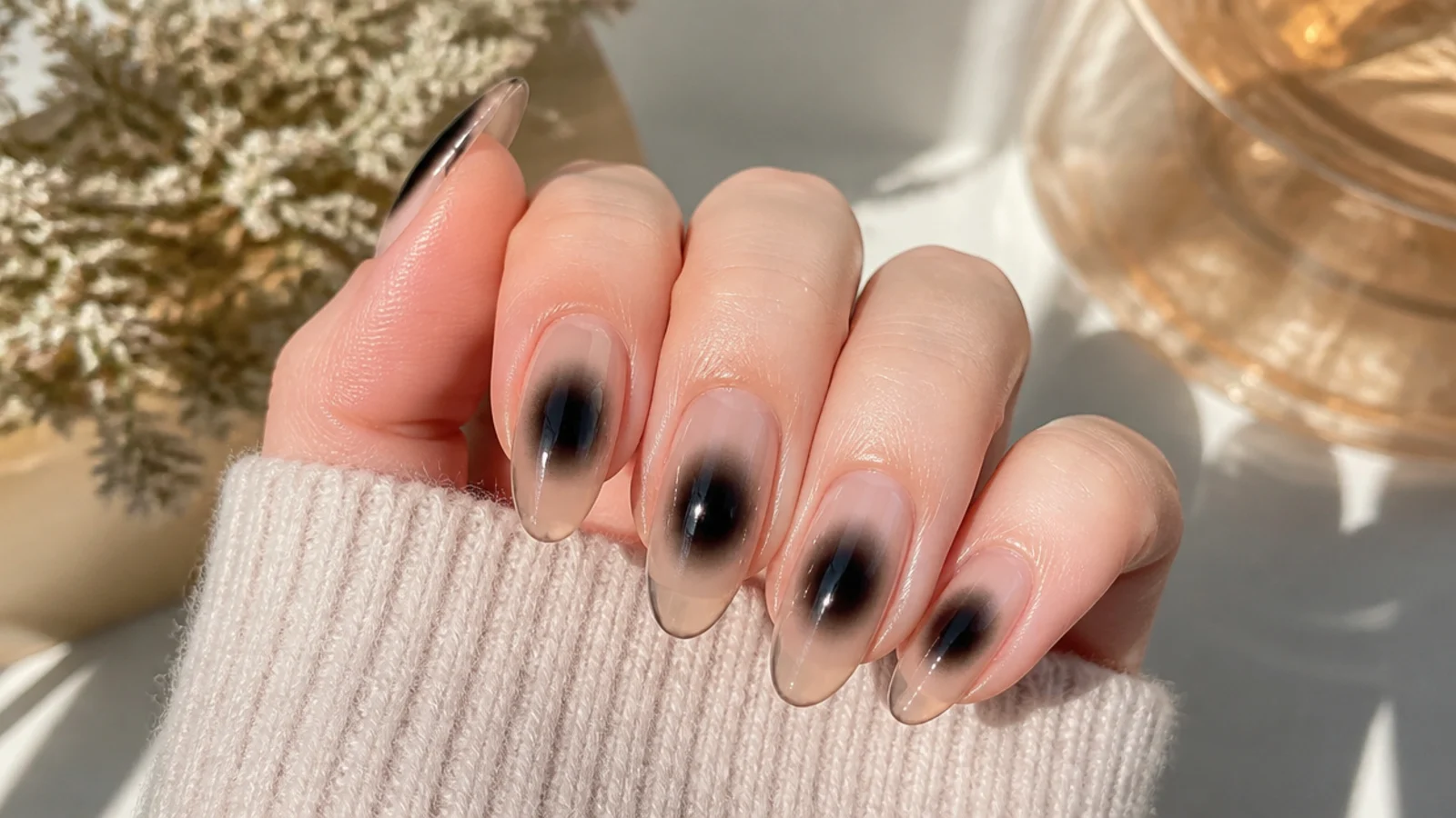 Long almond nails with a smoky black aura halo fading into a clear glossy base