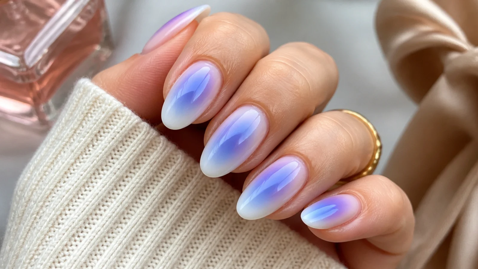 Medium almond nails with a blue aura halo ringed by purple on a milky base