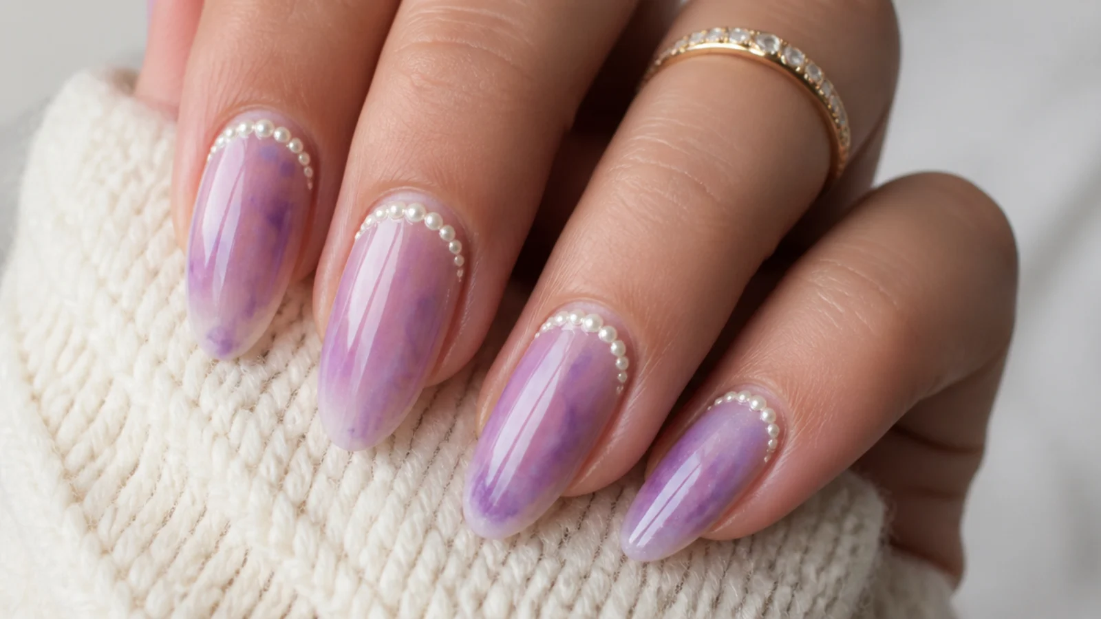 Almond nails with tiny white pearl beads glued along the cuticle line of a purple aura