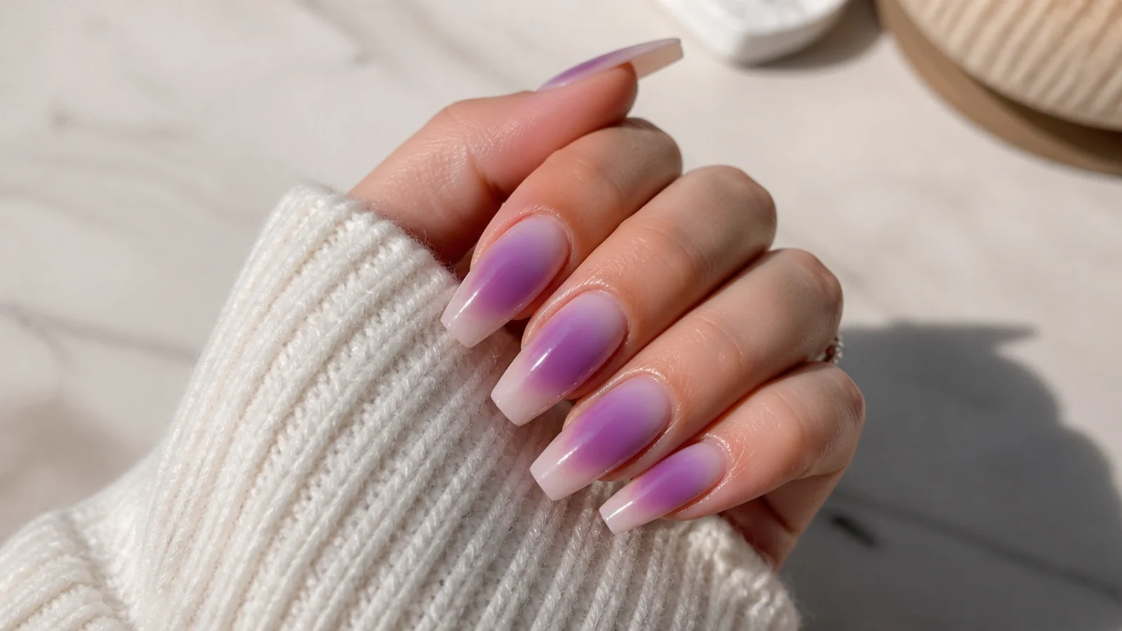 Long coffin nails with a violet aura halo floating in the center of a wide flat nail plate