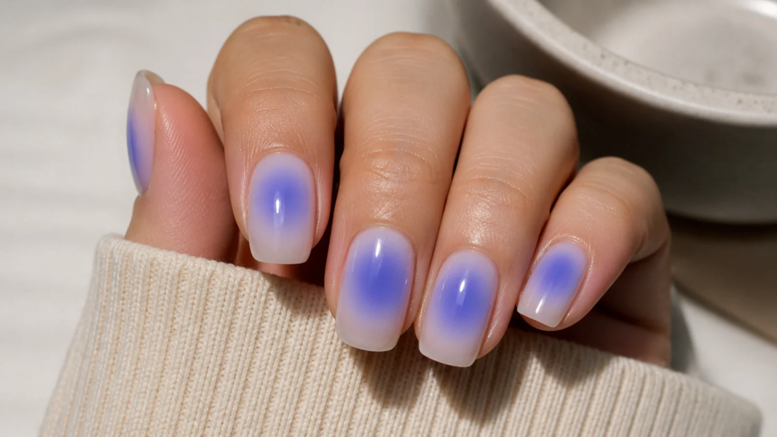 Periwinkle blue aura nails with a violet-leaning halo over a milky nude base