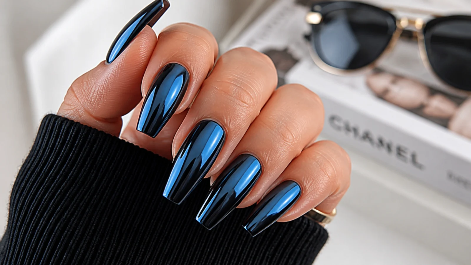 Long coffin nails with blue chrome over a black base creating a sharp mirror finish