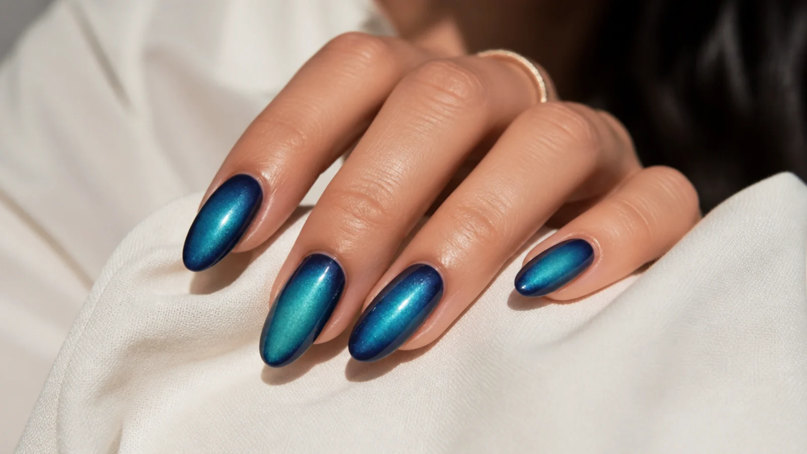 Ocean blue aura nails blending teal into deep sea blue across almond shaped nails