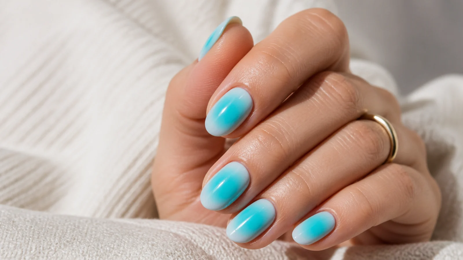 Bright turquoise blue aura nails on short almond nails with a glossy summer finish