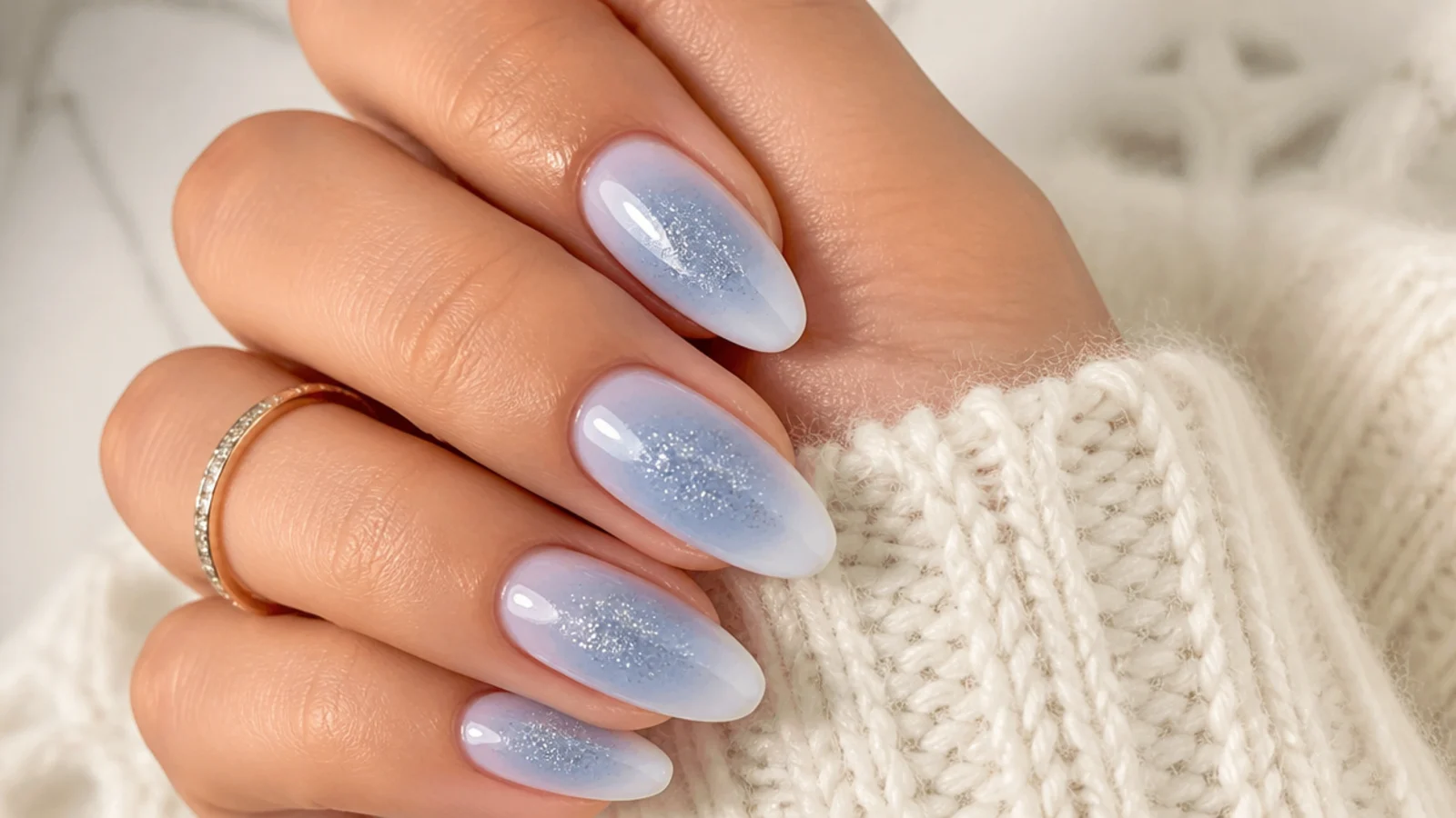 Icy blue aura nails with a frosted white edge and silver shimmer for a winter set