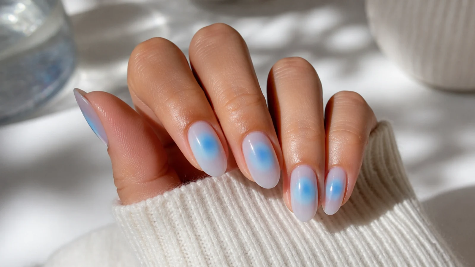 Almond blue aura nails with a baby blue glow blended out from the center of each nail