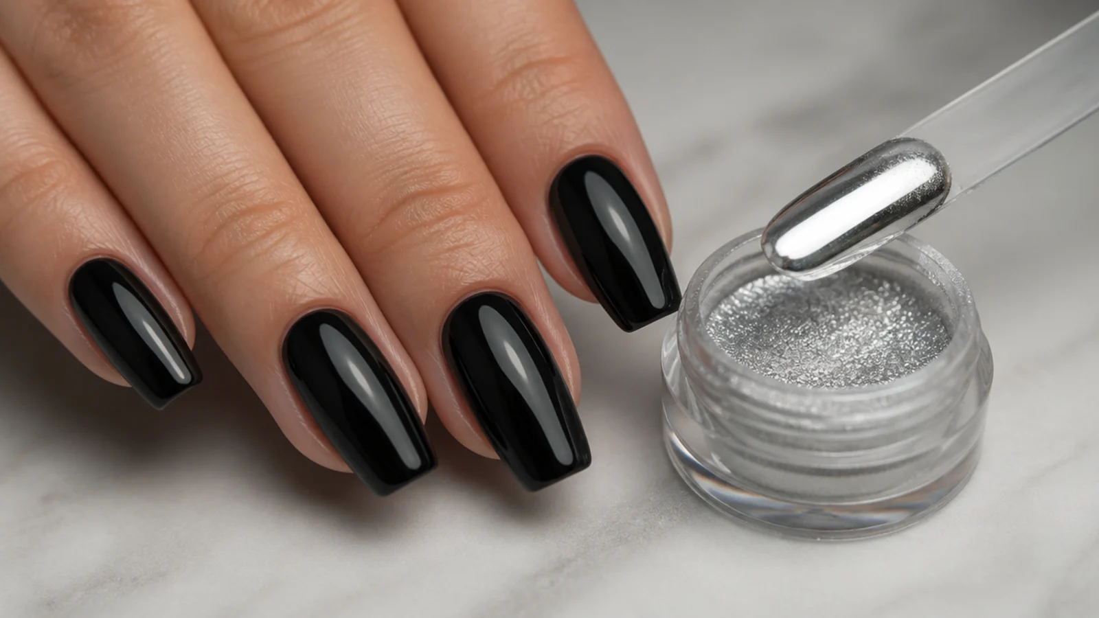 A single jar of silver mirror chrome powder with an applicator stick and a black gel base nail