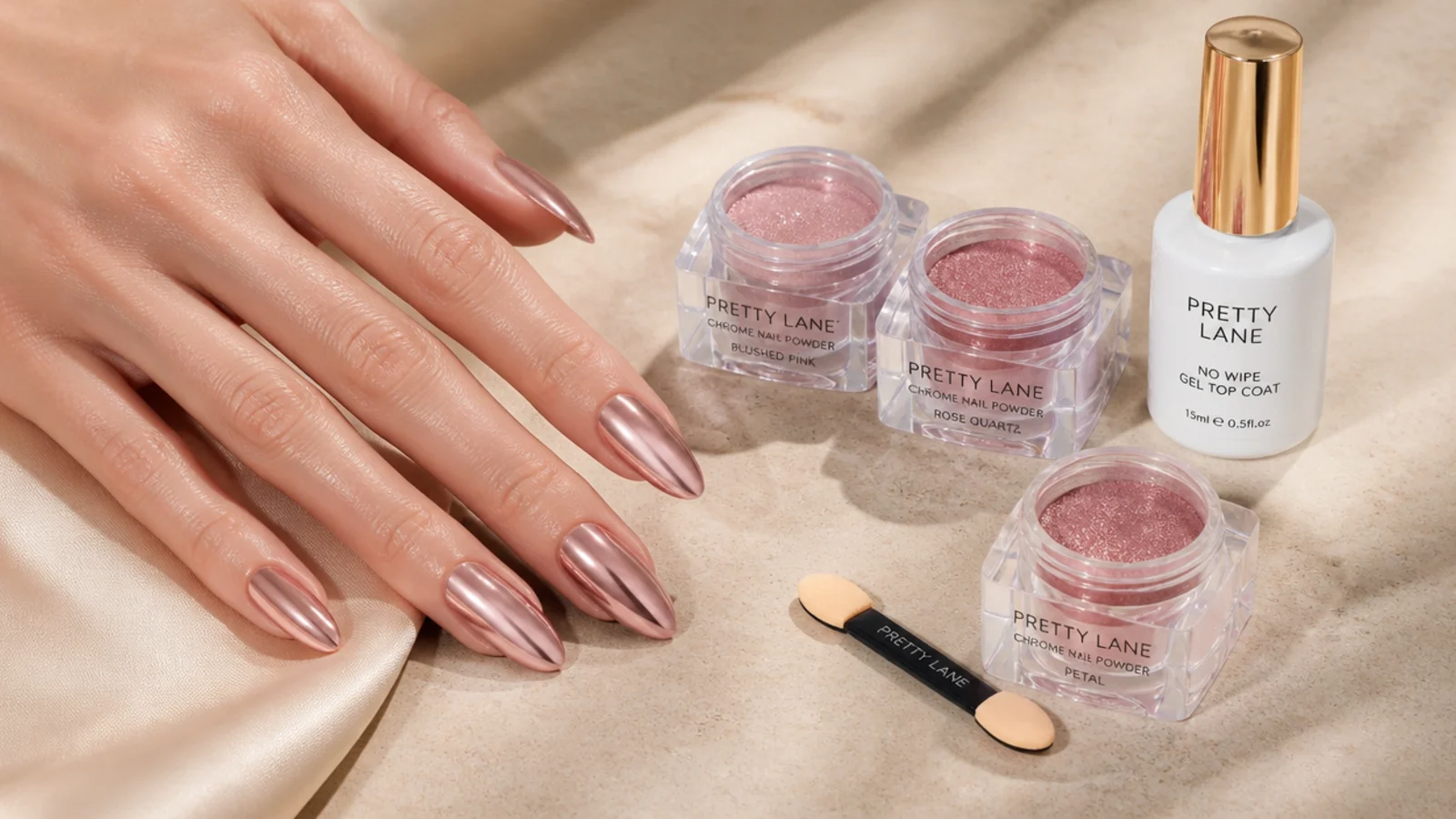 Chrome nail powder jars, an applicator sponge and a no-wipe gel top coat laid out beside mirror chrome almond nails