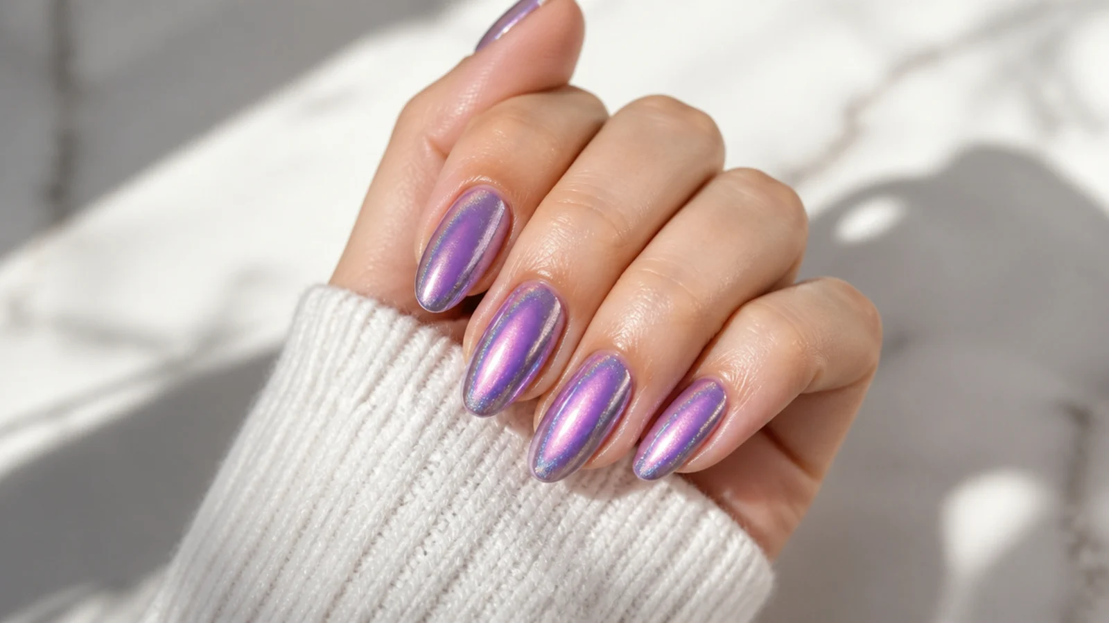 Long almond nails with a violet aura halo under a shifting chameleon chrome finish