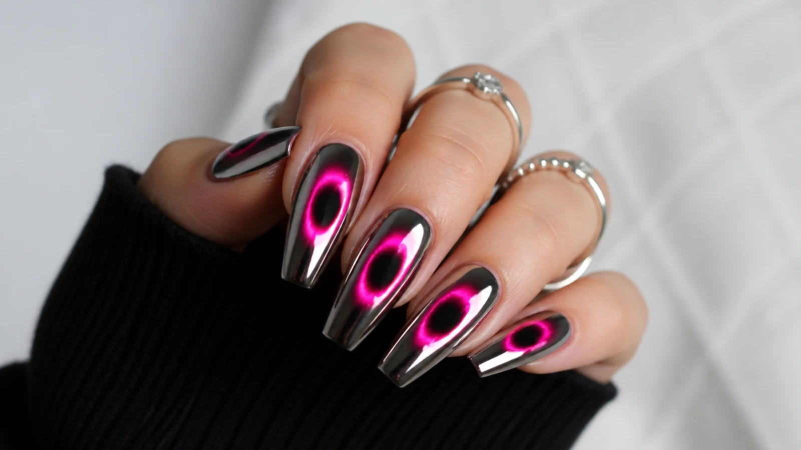 Long coffin nails with a bright neon aura halo over an opaque black base under sharp silver chrome
