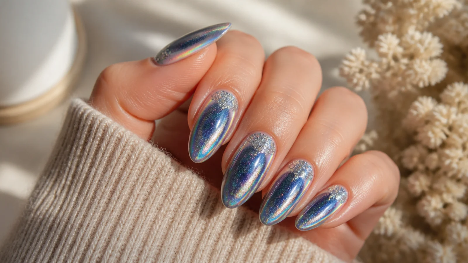Long almond nails with a navy aura halo under holographic chrome and fine silver glitter at the base
